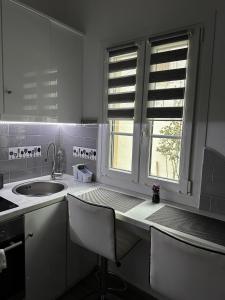 帕特莫斯Dominik apartment的白色的厨房设有水槽和窗户