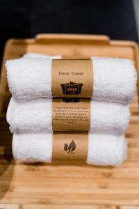 多哈sleep 'n fly Sleep Lounge & Showers, NORTH Node - TRANSIT ONLY的木托盘上堆着的毛巾