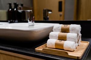 多哈sleep 'n fly Sleep Lounge & Showers, NORTH Node - TRANSIT ONLY的洗涤槽旁的切板上堆着的毛巾