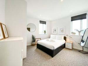 伦敦Amazing and 3 bedroom house in Deptford的白色卧室配有床和镜子