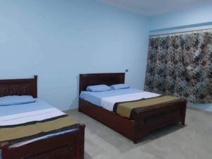 卢克索Nile Roof Hotel& Restaurant的蓝色墙壁客房的两张床