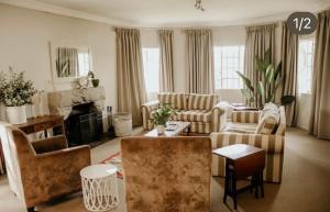 安德伯格Elgin Guest House的客厅配有沙发椅和壁炉