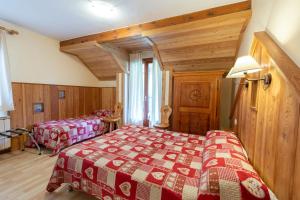 塞拉克卡斯卡德Spa酒店的一间带两张床的卧室,位于木天花板的房间
