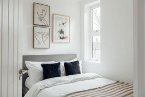 依尔福Modern 2 Bedroom Flat in Ilford, London的一间卧室配有一张带黑白枕头的床