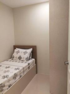 马尼拉Adria Residences - Emerald Garden - 2 Bedroom Unit for 4 person的白色客房内的小床,配有枕头