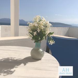 爱琴娜岛Hotel Areti的花瓶,花朵花朵花在桌子上