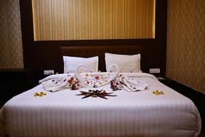 瓜廖尔Shubhim Hotel & Resort MIDWAY TREAT MPT FRANCHISE的一张铺有白色床单和鲜花的床