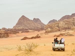 瓦迪拉姆Panorama camp jeep trips的一群人坐在沙漠的卡车后面
