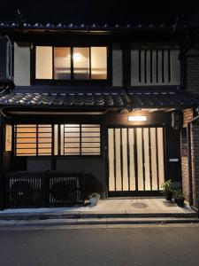 京都Kyomachiya Momo - Vacation STAY 29895v的前门房子,前面有两把长凳