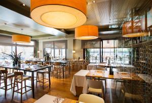 圣库加特德尔瓦勒斯屈加特餐厅与活动酒店的餐厅设有桌椅和大窗户。