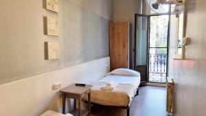 巴塞罗那Paraiso Hostel的小房间设有两张床和一张桌子