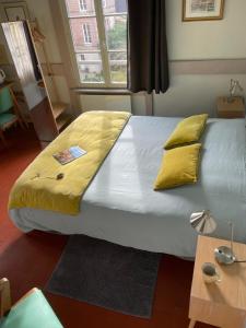 翁弗勒尔卡普辛民宿旅馆的一张带黄色枕头的大床
