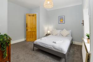 利物浦Air Host and Stay - Anfield cottage, 2 bedroom 2 bathroom的一间卧室配有一张床和一扇木门