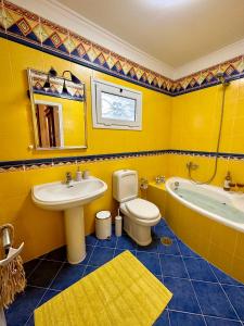 KalámionAegean Blue House - Spectacular Seaview的黄色的浴室设有水槽、卫生间和浴缸。
