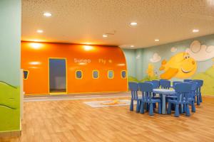 伊利索斯IALYSSOS BAY HOTEL的一间儿童房,配有橙色墙壁和蓝色椅子