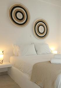RóziaOnverra Villa的白色卧室配有一张床,墙上挂有两张照片