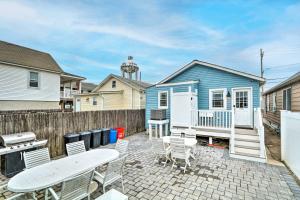希塞德高地Beach Retreat with BBQ, Patio and Outdoor Shower!的一个带椅子的庭院和蓝色的房子