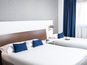 拉科鲁尼亚拉科鲁尼亚宜必思尚品酒店的两张带蓝色枕头的床