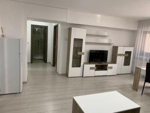拉姆尼库沃尔恰Cazare bloc nou ultracentral的客厅配有白色家具和冰箱。