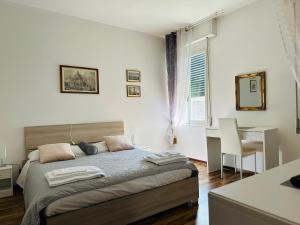 威尼斯La Dogaressa Guest House的一间卧室配有一张床、一张书桌和一个窗户。