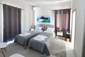 扎金索斯镇Villas Thalia的一间卧室配有两张床和一张桌子及椅子