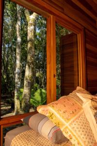 圣弗朗西斯科-迪保拉Morada do Xaxim - Chalé Hortência的卧室设有窗户,享有树林美景
