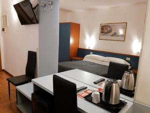 罗马茱莉亚酒店的小房间设有一张床和一张桌子