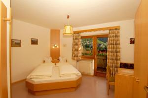 圣莱奥纳尔多因帕西里亚Hotel Gurschler的一间卧室设有一张大床和一个窗户。
