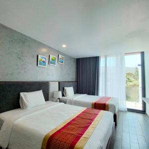 隆海Oceanami Villa Long Hải - Vũng Tàu的酒店客房设有两张床和窗户。