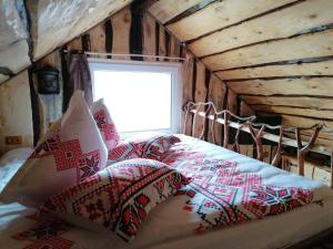 布拉索夫Casa rustica的一间卧室配有红色和白色枕头的床