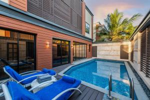 吉达Narcissus Obhur Resort & Spa的一个带蓝色椅子的游泳池