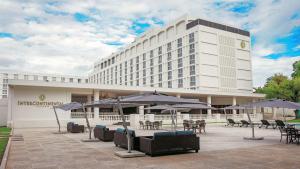 卢萨卡卢萨卡洲际酒店 的大楼前有桌子和遮阳伞的酒店