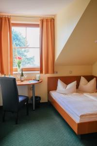 德累斯顿德累斯顿兰德豪斯酒店的配有一张床、一张书桌和一扇窗户的酒店客房