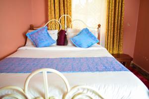 Lake View EstateHavan Furnished Apartments-Greensteads的一间卧室配有一张带蓝色枕头的床。