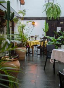 圭马尔Hotel rural casona Santo Domingo的一间设有桌椅和盆栽植物的餐厅