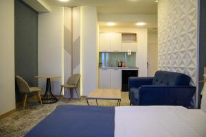 埃里温Rooftop Apart-Hotel的一间带蓝色沙发的客厅和一间厨房