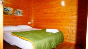 厄尔·萨洛Bungalows Park Albufera的木制客房内的一间卧室,配有一张床