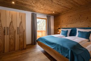 比绍夫斯维森Bergbauernhof Schoberlehen的一间卧室配有一张带蓝色床单的床和一扇窗户。