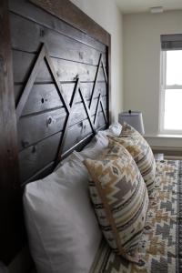 EncampmentPine Lodge的一张带木制床头板和枕头的床