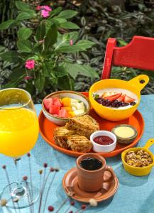 里约热内卢Eco Pousada Estrelas da Babilônia的一张桌子,上面放着一盘食物和一杯橙汁