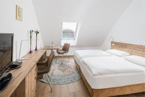 菲尔斯滕瓦尔德斯普雷勃艮酒店的一间卧室配有两张床、一张桌子和一台电视。