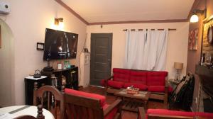 圣地亚哥-德尔埃斯特罗FINCA EL BRACO的客厅配有红色沙发和电视