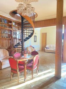 第比利斯K&N Guesthouse的一间带桌子和螺旋楼梯的用餐室