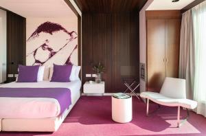 巴塞罗那Allegro Barcelona的一间卧室配有一张大床和一把椅子