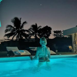 佩达西镇Ocean Breeze Cove - Luxury Retreat的一位晚上坐在游泳池里的女人