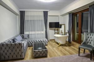 锡纳亚Chalet jolie Luxury Vila Sinaia的带沙发和浴缸的客厅