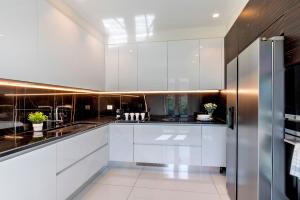 普拉托Genteel Home Prato的厨房配有白色橱柜和不锈钢冰箱
