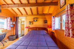 Les CombesSauvage的木墙客房内的一张大床