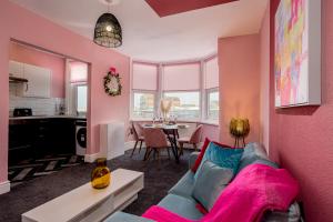 克利夫利斯Charles Alexander Short Stay - Botanical House的客厅设有蓝色的沙发和粉红色的墙壁