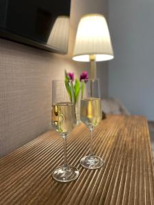 梅灵Hotel Zum Fährturm的桌子上放着两杯葡萄酒和一瓶鲜花